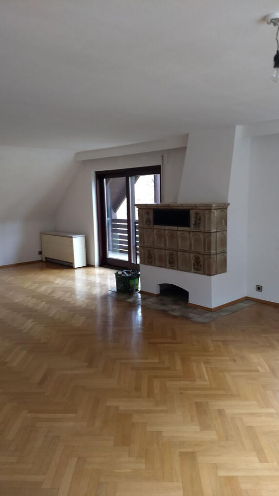 Wohnzimmer mit Kachelofen und Zugang zum Balkon Obergeschoss